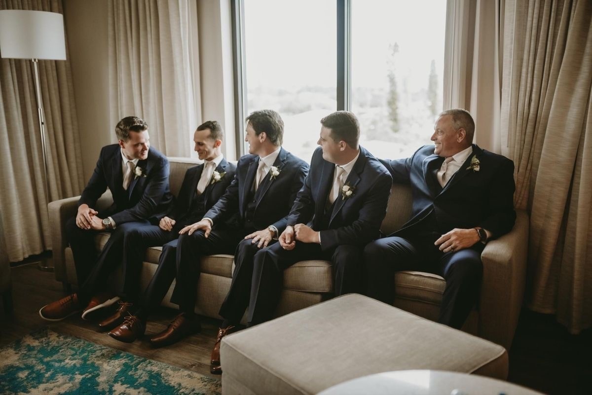 Groomsmen Seated Indoors Wearing Formal Suits