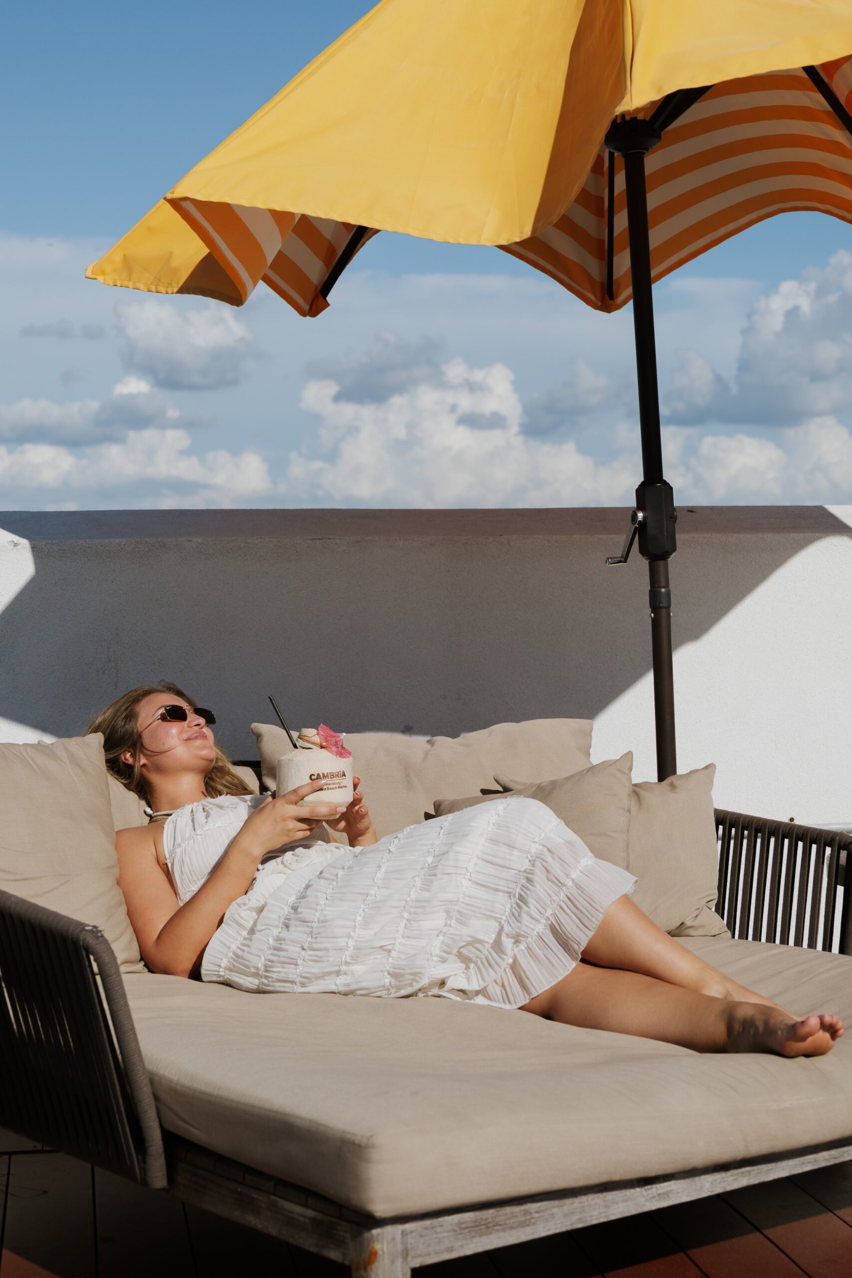 Woman Relaxing on Outdoor Lounge Chair Under an Umbrella
