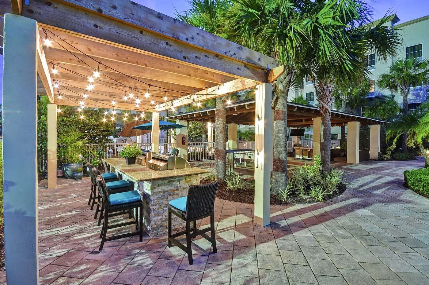 Outdoor Dining Area with Seating Under Lighted Pergola